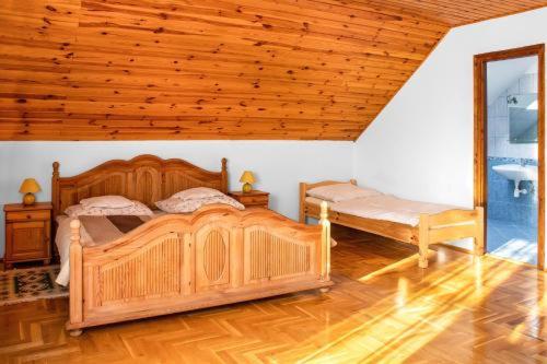 a bedroom with a large wooden bed and a window at Wellez Vendégház in Sajóvelezd