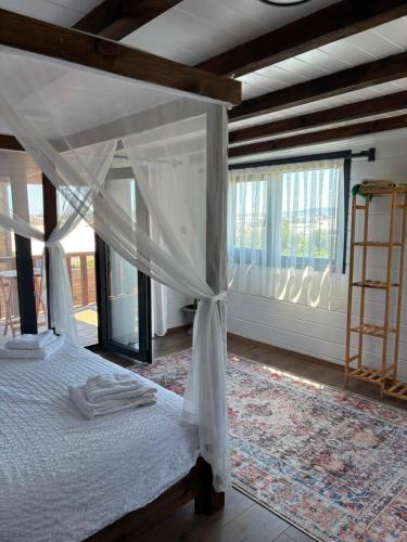 a bedroom with a canopy bed and a large window at Villa Myra in Beymelek