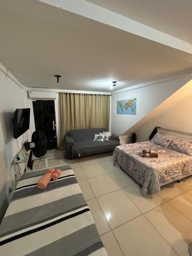 a bedroom with two beds and a tv in it at Hospedagem Dorna Casa 6A Itaguaí in Itaguaí