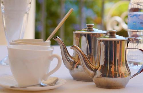 a group of tea pots and cups on a table at DANA KIGALI HOTEL in Kigali