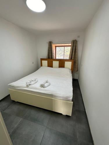 a bedroom with a bed in a room with a window at carmel cabins suite 12 in Yājur