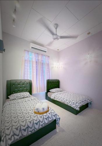 a room with two beds and a ceiling fan at M & V butterworth in Butterworth