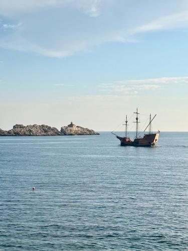 a boat sitting in the middle of a large body of water at Villa Misita Elegant SeaView Rooms in Dubrovnik