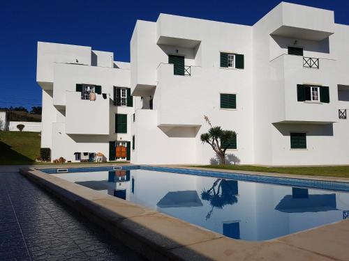 un edificio blanco con una piscina frente a él en O Paraíso no Terraço, en Foz do Arelho