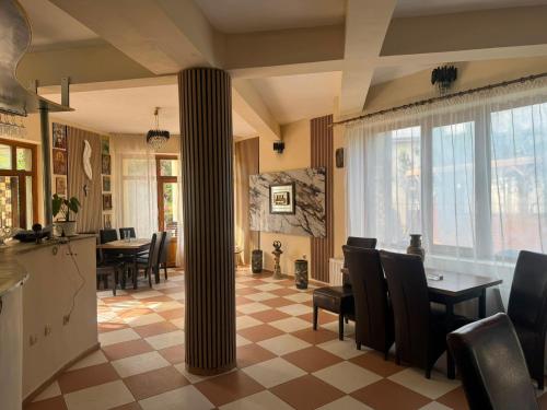 a dining room with a column and a table and chairs at Vila George in Eforie Sud