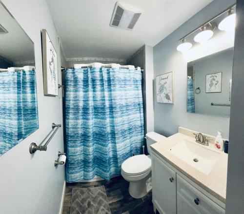 a bathroom with a toilet and a shower curtain at Wake up 2 Quiet Ocean Views, centrally located A1A in Ormond Beach