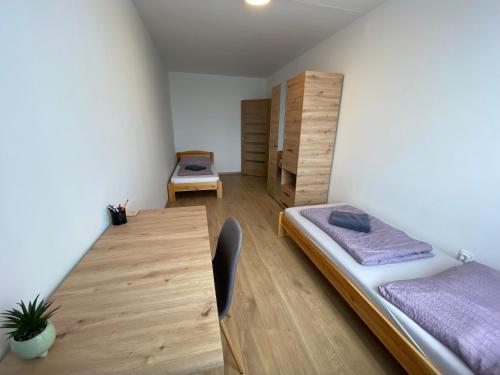 a bedroom with a bed and a wooden table at Nagyerdő Naplemente Apartman Debrecen in Debrecen