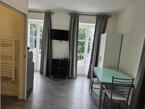 a dining room with a table and a refrigerator at Studio in Bonny-sur-Loire