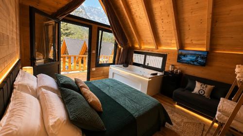 a bedroom with a bed in a room with windows at Thethi Villas in Theth