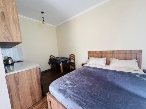 a small bedroom with a bed and a kitchen at Due apartments in Borjomi
