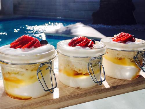three jars of dessert with strawberries in them on a tray at The Glen Boutique Hotel & Spa in Cape Town