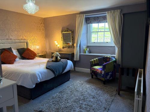 a bedroom with a bed with a teddy bear sitting on it at Bolton arms downholme in Richmond