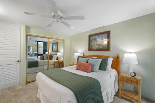 a bedroom with a bed with a ceiling fan at Kaleialoha 211 · KA 211 OceanFront 1BD Whale Watch Relax Getaway in Kahana