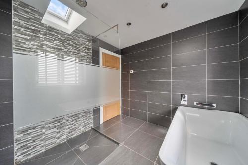 a bathroom with a bath tub and a window at Modern Large 4-Bed Property sleeps 10 in Abergele in Abergele