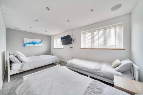 a white room with two beds and a tv at Modern Large 4-Bed Property sleeps 10 in Abergele in Abergele