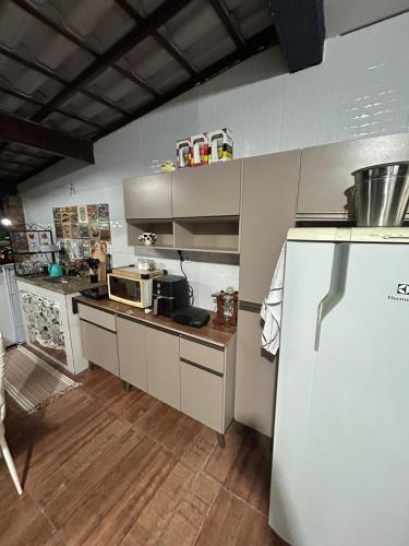 a kitchen with a refrigerator and a counter top at Hospedagem Dorna Itaguaí Casa 6B in Itaguaí