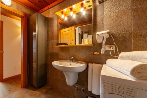 a bathroom with a sink and a toilet and a mirror at Residenza Bagni & Miramonti in Cavalese