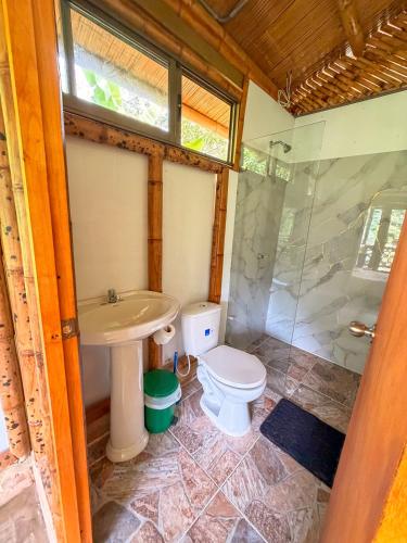 a bathroom with a toilet and a sink and a shower at Cabaña ALAK in La Vega