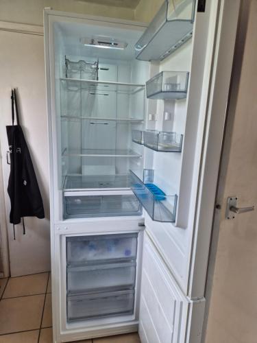 an empty refrigerator with its door open at Cozy Flat in Steyning
