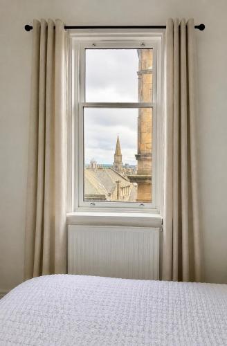 a bedroom window with a view of a city at Snowdon Apartments in Stirling