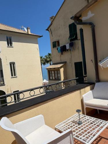 a balcony with a table and chairs on a building at Riviera Blu Rooms in Laigueglia