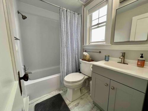 a bathroom with a toilet and a sink and a window at Inn on Willard in South Portland