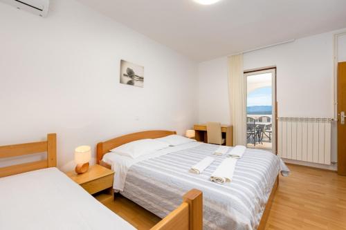 a bedroom with two beds and a balcony at Rooms Vera in Porat