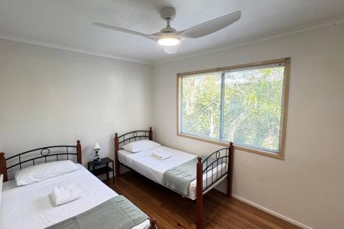 two beds in a room with a window at Pool house in Marsden