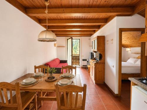 a kitchen and dining room with a wooden table and chairs at Residence Borgo Al Sole in Sappada