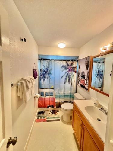 a bathroom with a sink and a toilet and a window at Steps to Private Beach Access King Beds in Ormond Beach