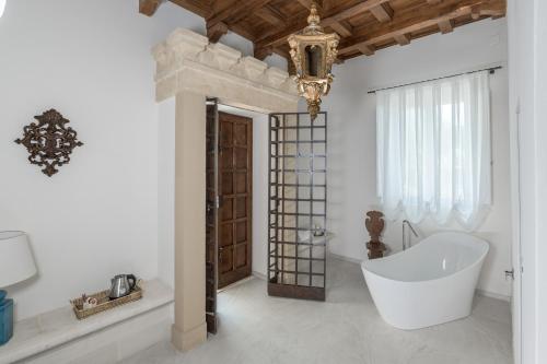 a bathroom with a tub and a chandelier at Villa Tuzzo in Lecce