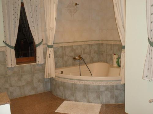 a bathroom with a tub and a window at Sierras y Valles in Salvatierra de los Barros