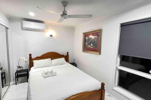 a bedroom with a bed with a ceiling fan and a window at SPA House 4 BDR 5 beds Master with AC) in Boronia Heights
