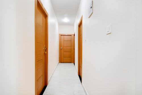 a hallway with two wooden doors at Hotel O by OYO Eco Greenway Retreat in Salua