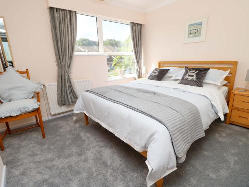 a bedroom with a large bed and a window at Camellia Cottage in Wimborne Minster