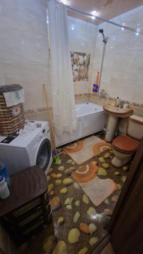 a bathroom with a tub and a toilet and a sink at Квартира1 in Balqash