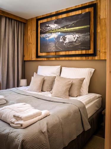 a bedroom with a large bed with a picture on the wall at Bugiem i Miodem in Siemiatycze