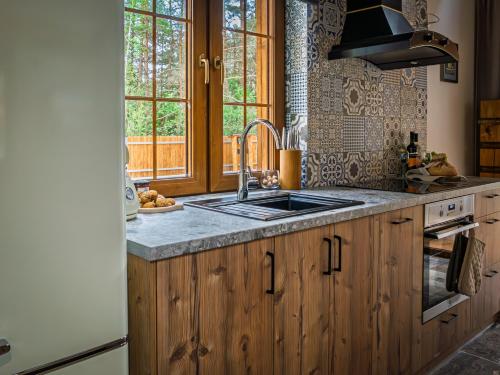a kitchen with wooden cabinets and a sink at Bugiem i Miodem in Siemiatycze