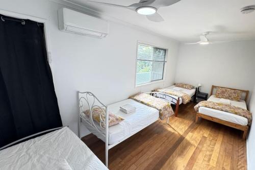 a room with two beds and a couch and a chair at Pool house for BIG Groups with Free parking in Marsden