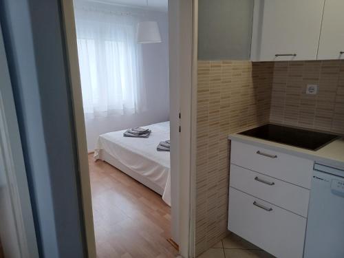 a small kitchen with a bed in a room at Apartmani Sidro in Privlaka
