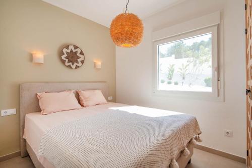 a bedroom with a bed with pink pillows and a window at Villa Mawaki Calpe in Calpe