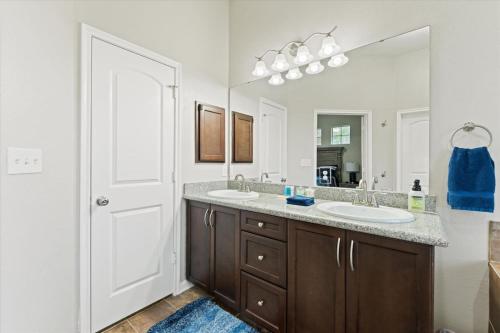 a bathroom with two sinks and a large mirror at Pines and Patio Hideaway in Conroe
