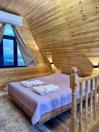 a bedroom with a bed in a wooden ceiling at Tengri House A-Frame Issyk-Kul in Kaji-Say