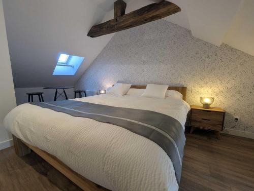 a bedroom with a large bed in a attic at Gîte le saint goth in Bricon