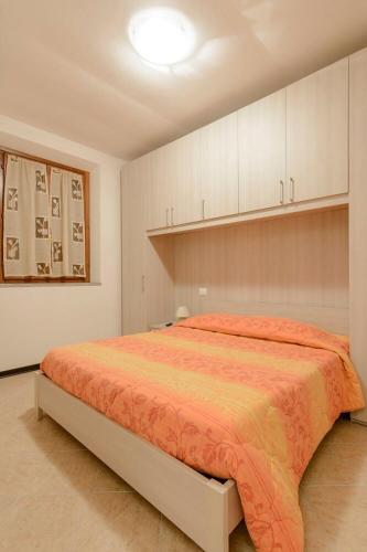 a bedroom with a large bed with an orange blanket at Casa Bice Casa Vacanze in Case Pieve al Toppo