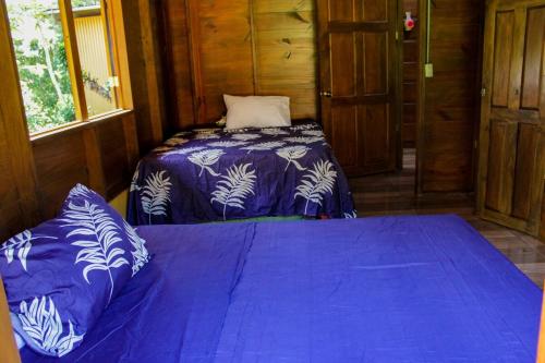 a bedroom with a bed with a blue comforter at Quinta La Carmencita in Santa Elena