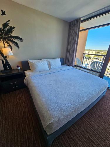 a bedroom with a large bed and a balcony at Oceanview Room at Landmark Resort in Myrtle Beach