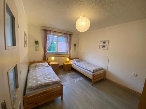 a room with two beds and a window at Apartmán U Jiroutů in Rokytnice v Orlických Horách