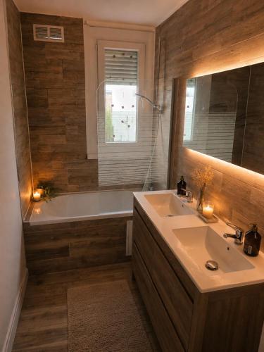 a bathroom with a sink and a bath tub at Le cocon du lac in Montargis