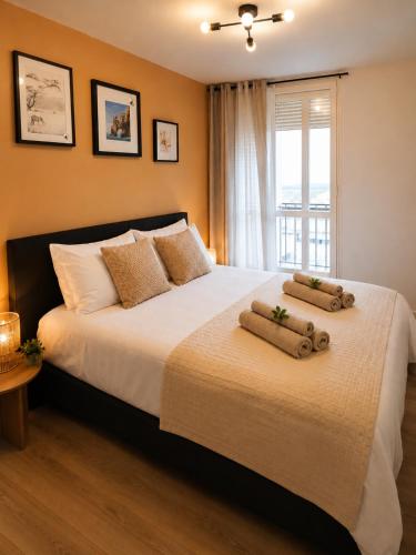a bedroom with a large bed with two pillows on it at Le cocon du lac in Montargis